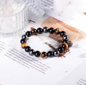 This **Triple Protection Bracelet** combines the powerful energies of **Tiger Eye**, **Hematite**, and **Black Obsidian** in 12mm beads, offering protection, grounding, and emotional healing. Known for enhancing confidence, focus, and shielding against negative energy, this bracelet is ideal for those seeking balance and protection in their daily life. Each piece is unique, with natural stones that may vary slightly in color and pattern. Perfect for enhancing your energy or as a thoughtful gift.